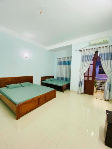 a bedroom with two beds and a window at Nhà Nghỉ 846-B44 in Vung Tau