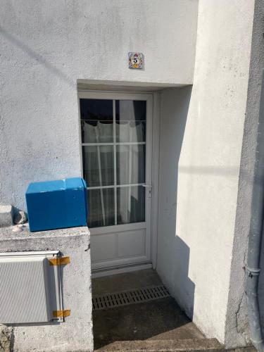 une porte d'un bâtiment avec une boîte bleue à côté dans l'établissement Maison de pêcheur Roch Priol, à Quiberon
