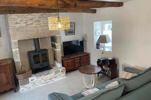 un salon avec une cheminée et une télévision dans l'établissement Maison de pêcheur Roch Priol, à Quiberon