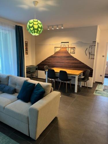 uma sala de estar com um sofá e uma mesa em Fűzliget2-Mistral Garden em Balatonfuzfo