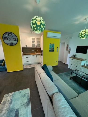 uma sala de estar com um sofá e um relógio em Fűzliget2-Mistral Garden em Balatonfuzfo
