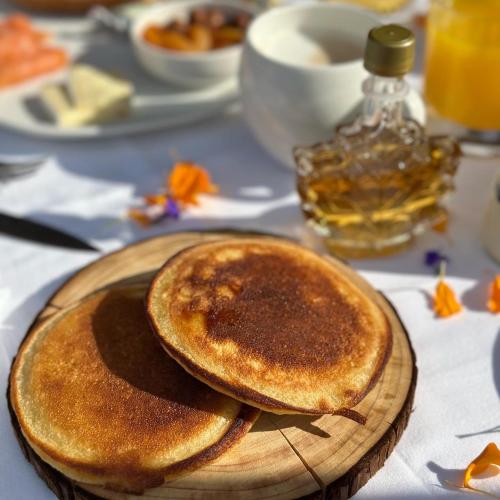 Dos panqueques en un plato de madera sobre una mesa. en Hotel Le V de Vaujany, en Vaujany