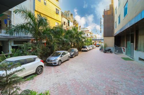 a row of cars parked on a brick street at Hotel V'ertu in New Delhi