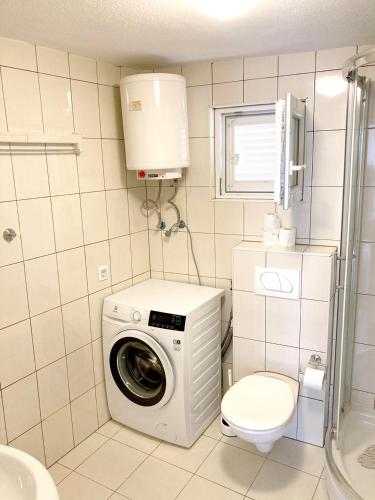 a bathroom with a washing machine and a toilet at Levanda in Trogir