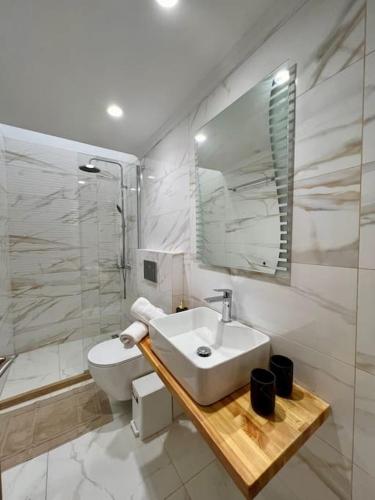 a bathroom with a sink and a toilet and a mirror at Villa Marinos in Kalamaki
