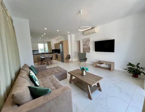 a living room with a couch and a table at Villa Marinos in Kalamaki