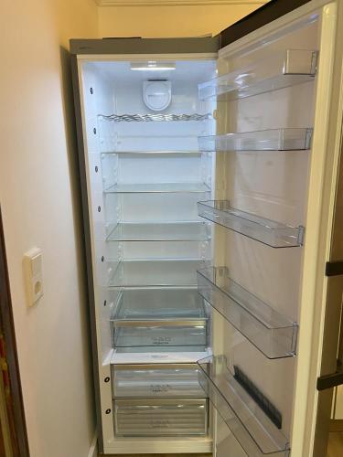 an empty refrigerator with glass shelves in a room at stylisches Doppelzimmer in Kleve in Kleve