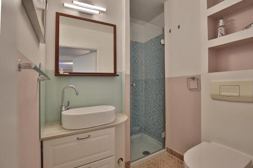 uma casa de banho com um lavatório, um espelho e um chuveiro em Ferienbungalow Erlenweg 20 Erlenweg 20 Appartement 3 Niendorf Ostsee em Niendorf