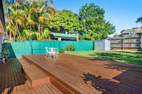 a deck with two white chairs on top of it at The Mellow Haven in Gold Coast