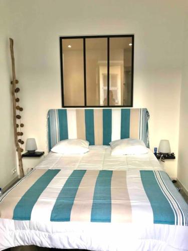 - un lit avec une tête de lit rayée dans une chambre dans l'établissement CHeZ FANNY - Ravissant 2 pièces avec balcon, à Antibes
