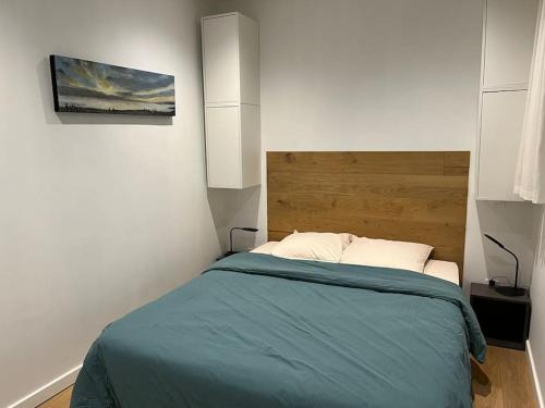 een slaapkamer met een bed en een schilderij aan de muur bij LE CLOS in Sainte-Savine