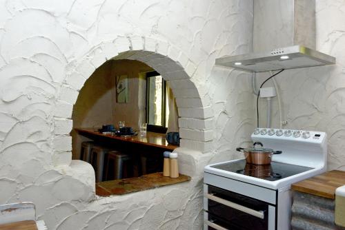 een keuken met een fornuis en een boog in de muur bij The Studio at Meadowbrook in Kersbrook