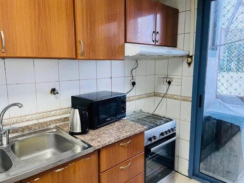 a small kitchen with a sink and a microwave at Relaxation Quiet Room 2 in Abu Dhabi