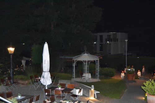 a gazebo with a white umbrella and tables and chairs at Weinhaus Steppe Hotel 3***Superior und Weinstube in Waldbronn