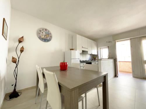 una cucina e una sala da pranzo con tavolo e sedie in legno di Nuovo Appartamento Ristrutturato in Corte Interna a La Maddalena