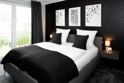 a bedroom with a large bed with black walls and a window at Hotel Deluxe in Dorsten
