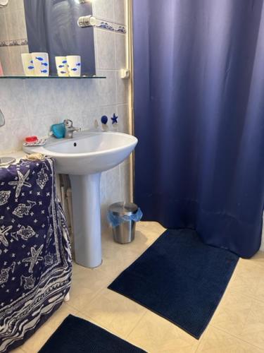 La salle de bains est pourvue d'un lavabo et d'un rideau de douche bleu. dans l'établissement T3 Corniche Sète Rare, à Sète