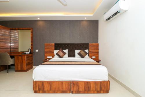 a bedroom with a large bed and a desk at OPO Hotel Vertu,Free Airport Pick-up in New Delhi