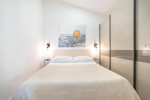 a white bedroom with a large white bed at Apartman L&L in Makarska