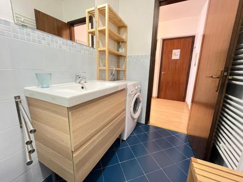 a bathroom with a sink and a washing machine at Appartamento Warner in Grado