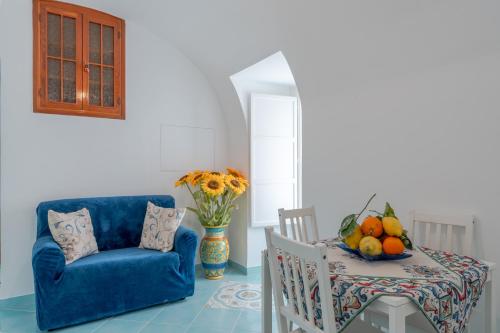 ein Wohnzimmer mit einem Tisch und einem blauen Sofa in der Unterkunft Little House in Minori