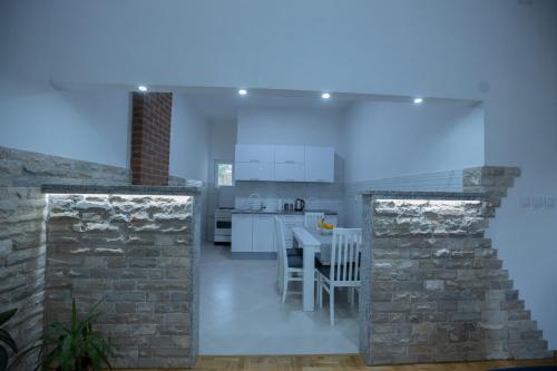 トレビニェにあるApartman Jelićの白いキャビネットとレンガの壁が備わるキッチン