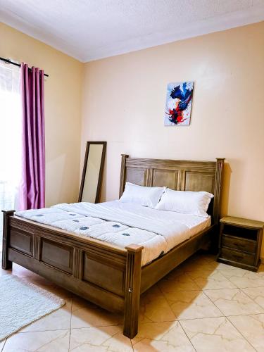 um quarto com uma cama de madeira num quarto em GEORGE’S PLACE em Kira