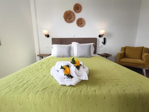 a bedroom with a bed with towels and flowers on it at Nemesis in Fira
