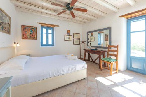a bedroom with a bed and a desk and a window at Marpissa Paros house Casa Mira in Kampos Paros