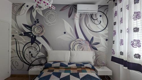 ein Schlafzimmer mit einem Bett mit einem Blumenwandbild an der Wand in der Unterkunft Appartamento zona Grazie in Ancona