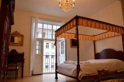 a bedroom with a canopy bed and a window at Rent a Room Copenhagen in Copenhagen