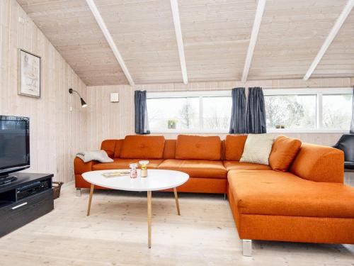 sala de estar con sofá naranja y mesa en 6 person holiday home in B rkop, en Egeskov