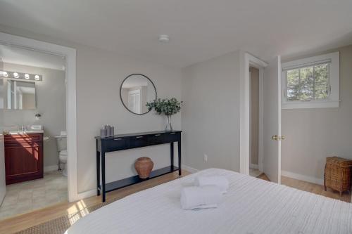 a white bedroom with a bed and a mirror at Short walk to Bayside Beach in Eastham