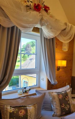 a bedroom with a bed with a large window at Ferienwohnung Oase in Peißenberg