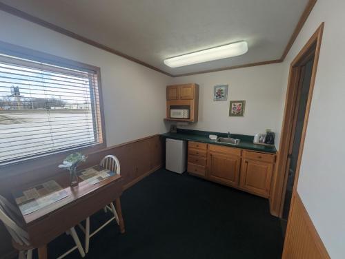 um quarto com uma cozinha com uma mesa e uma janela em Auburn Inn Motel 
