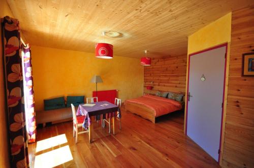 een slaapkamer met een bed en een tafel in een kamer bij Noyers du Soleil, Chambre d'hôte avec petit déjeuner à proximité de Gap in La Bâtie-Vieille