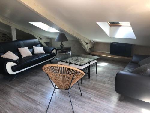 a living room with a couch and a table at Ecuries de Saint Maurice- Maison d'hôtes de Gondou in Lacapelle-Marival