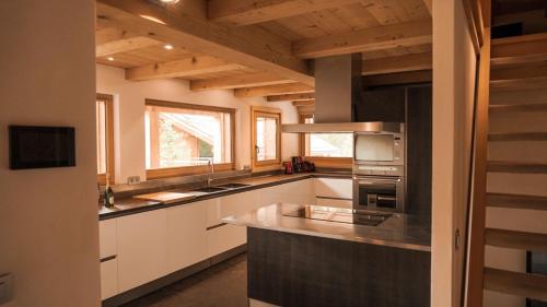 a kitchen with white cabinets and a stove top oven at Chalet Isabelle Mountain lodge 5 star 5 bedroom en suite sauna jacuzzi in Chamonix-Mont-Blanc