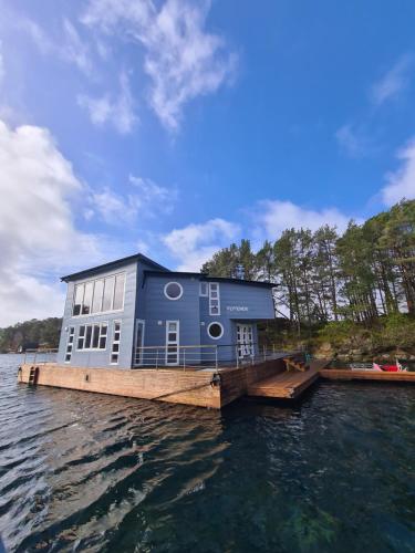 a house on a dock on a body of water at Floating House Bergen in Bergen