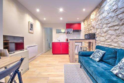 - un salon avec un canapé bleu et un mur en pierre dans l'établissement L'auberge rit !, à Périgueux