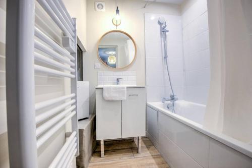 une salle de bain avec un lavabo, une baignoire et un miroir dans l'établissement L'auberge rit !, à Périgueux