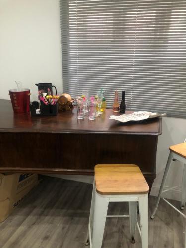 a wooden desk with glasses on it next to a window at HOME Hertford in Hertford