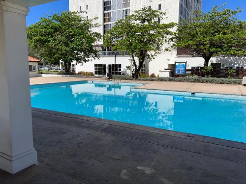 a large blue swimming pool with buildings in the background at Beach access apartment in Portmore