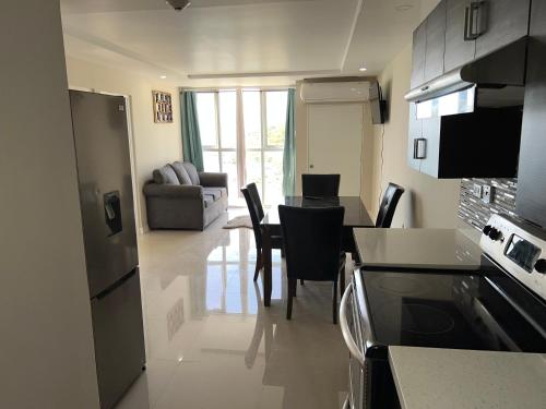 a kitchen and living room with a table and chairs at Beach access apartment in Portmore
