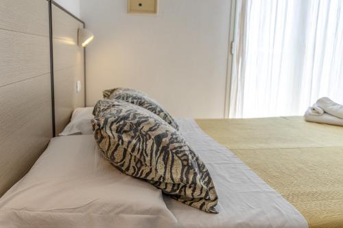 a bedroom with a bed with pillows on it at Hotel Atlantic in Gatteo a Mare