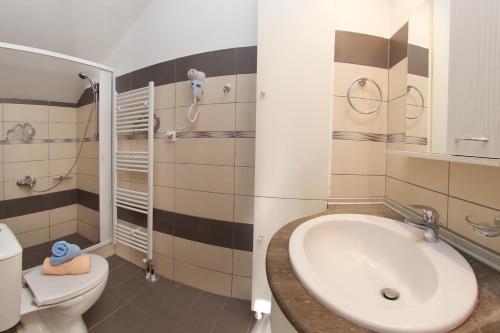 a bathroom with a sink and a toilet at Orchid Garden Apartment in Sami