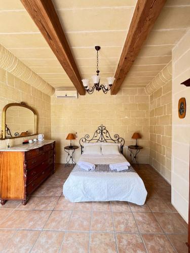 a bedroom with a bed and a vanity and a mirror at Sant Antnin B&B in Munxar