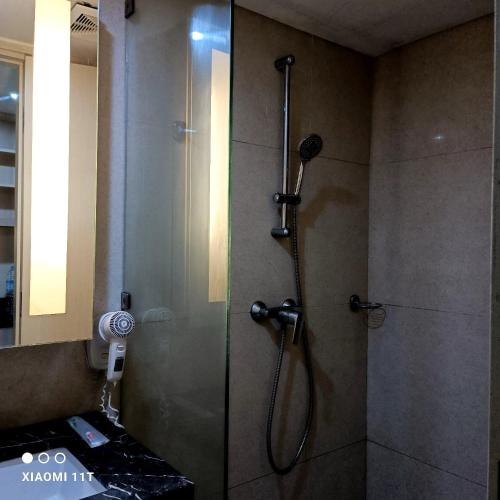 y baño con ducha y puerta de cristal. en Apartment Louise kienne, en Semarang