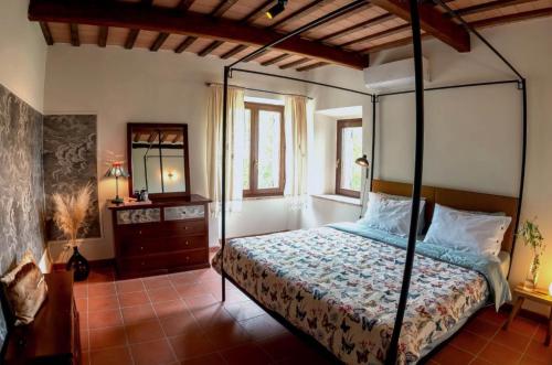 a bedroom with a canopy bed and a mirror at Villa Verdicchio - B&B for winelovers in Cupramontana