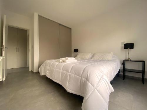 1 dormitorio con 1 cama grande con sábanas blancas en Pionero en Neuquén